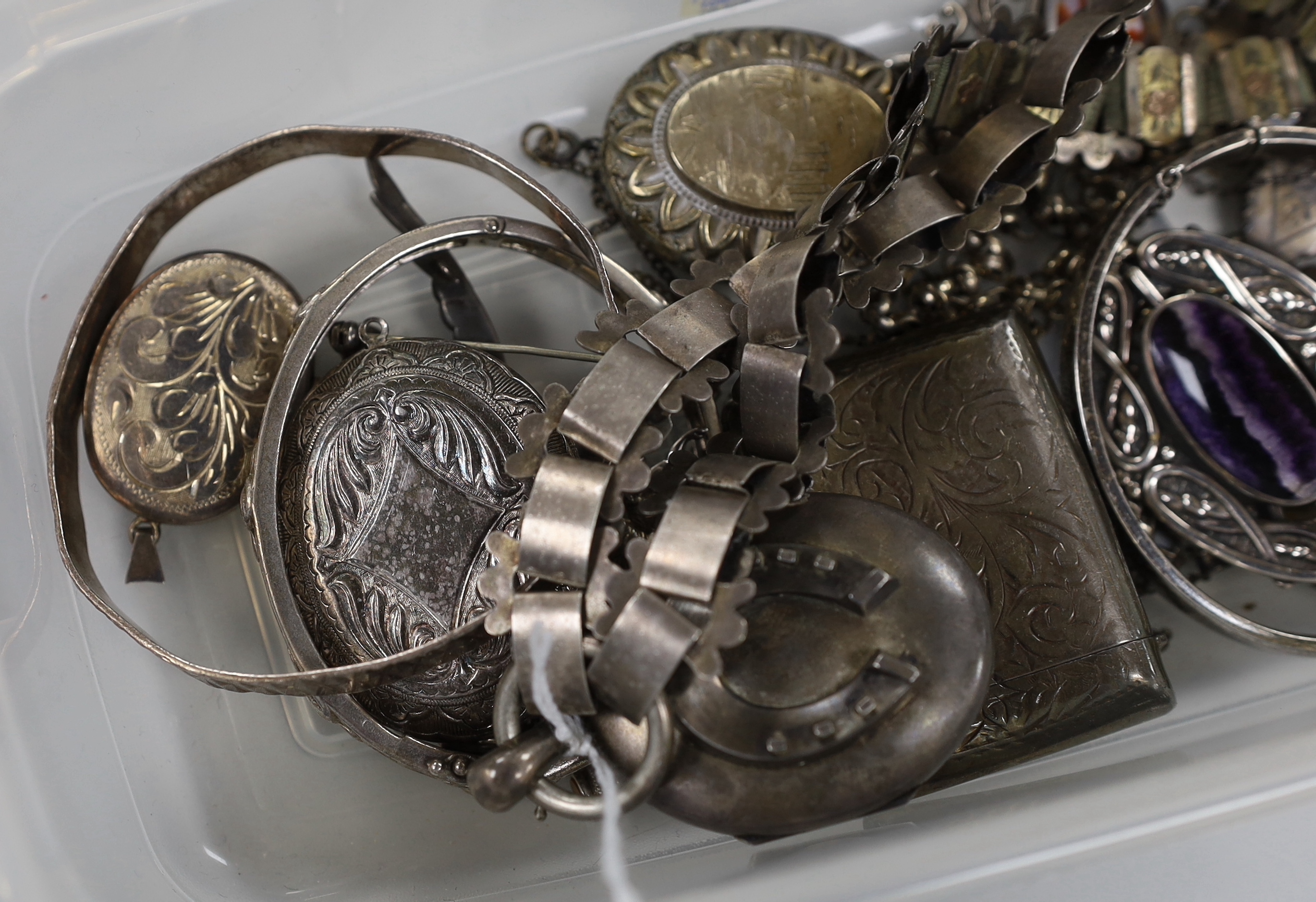 A Victorian silver oval locket, on a white and yellow metal chain, overall 52cm and other jewellery including silver and white metal lockets, vest case etc